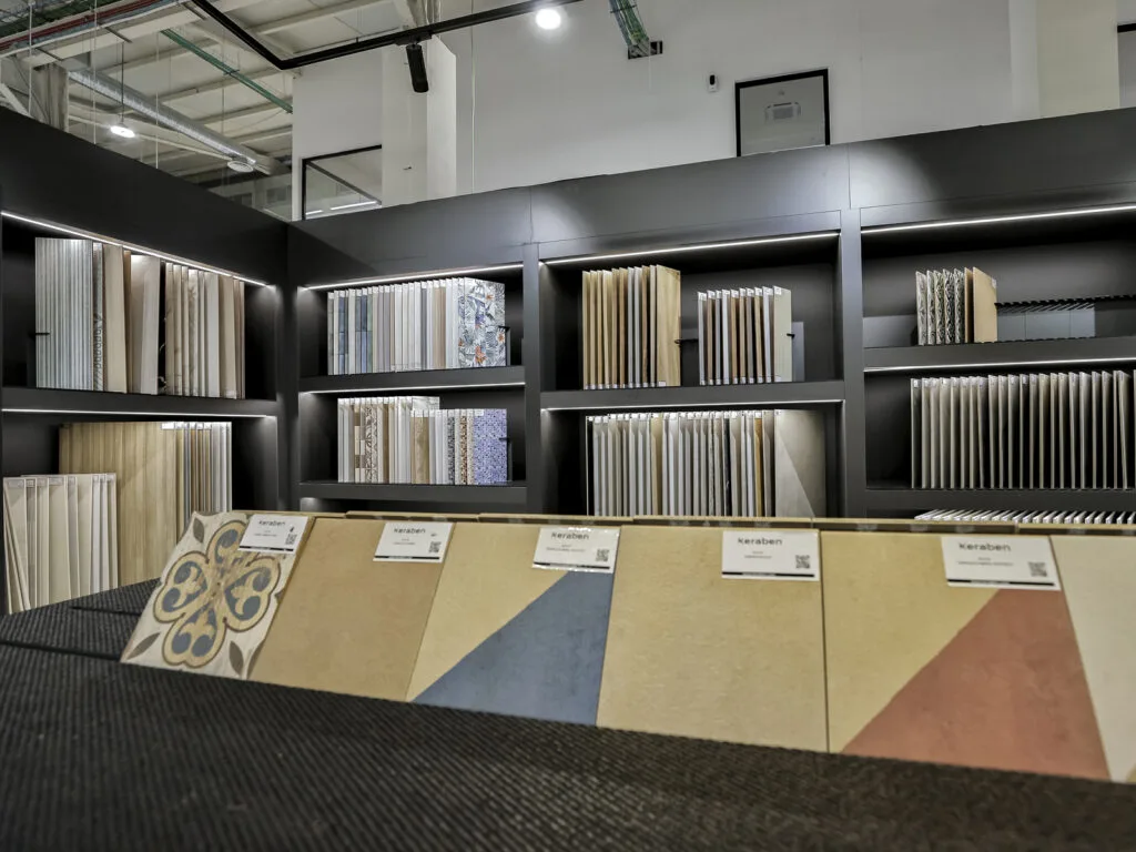 Estanterías de muestrarios y piezas de colores expuestas en el showroom, vista frontal