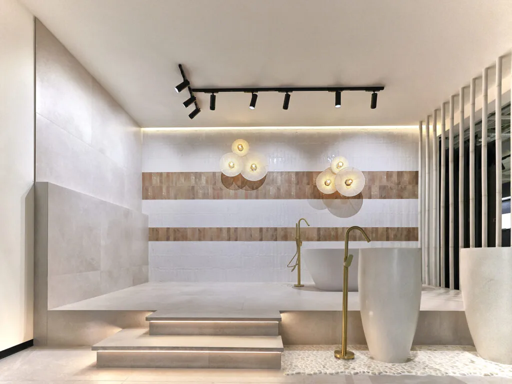 Bañera exenta, lavabo de pie y cenefa de madera en el showroom