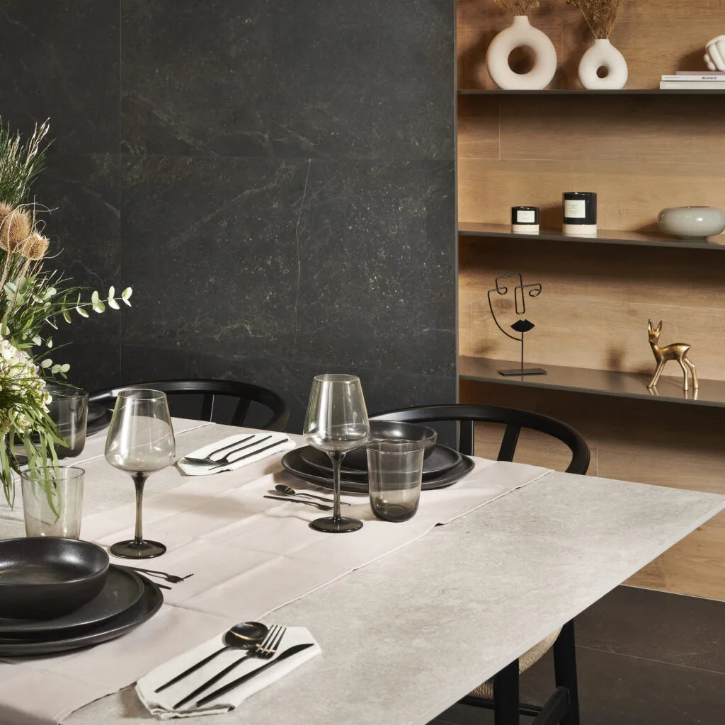 Comedor con revestimiento Bleuemix negro en gran formato y mesa clara