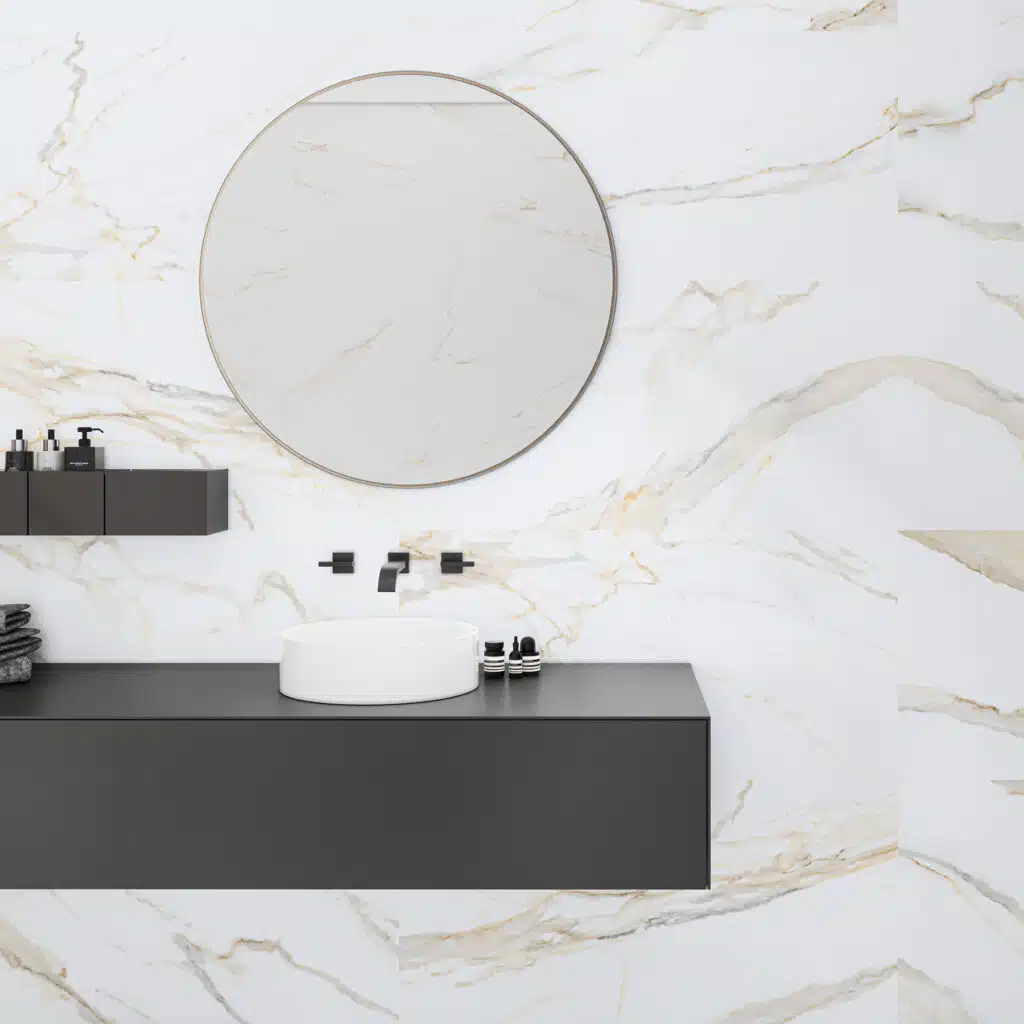 Baño con revestimiento Calacatta Gold efecto mármol blanco y espejo redondo