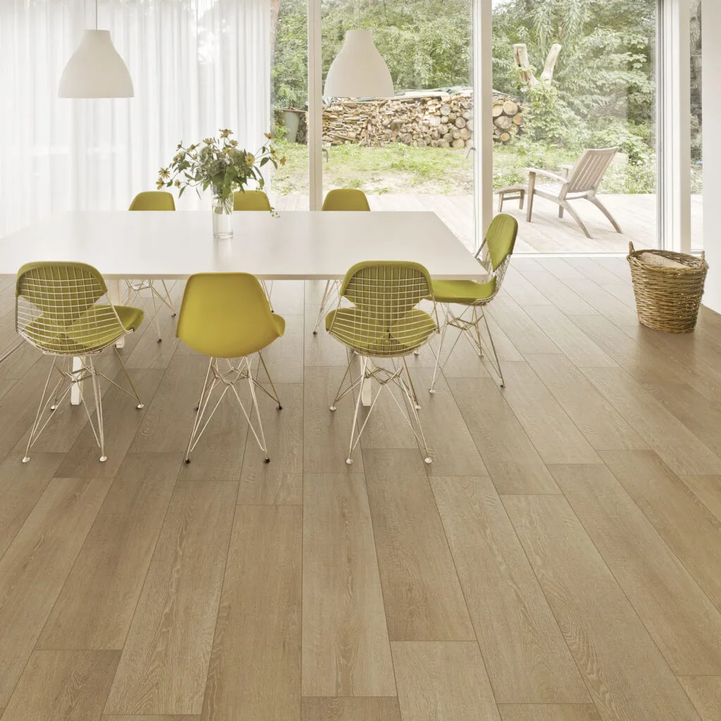 Comedor con pavimento Savia efecto roble y sillas amarillas