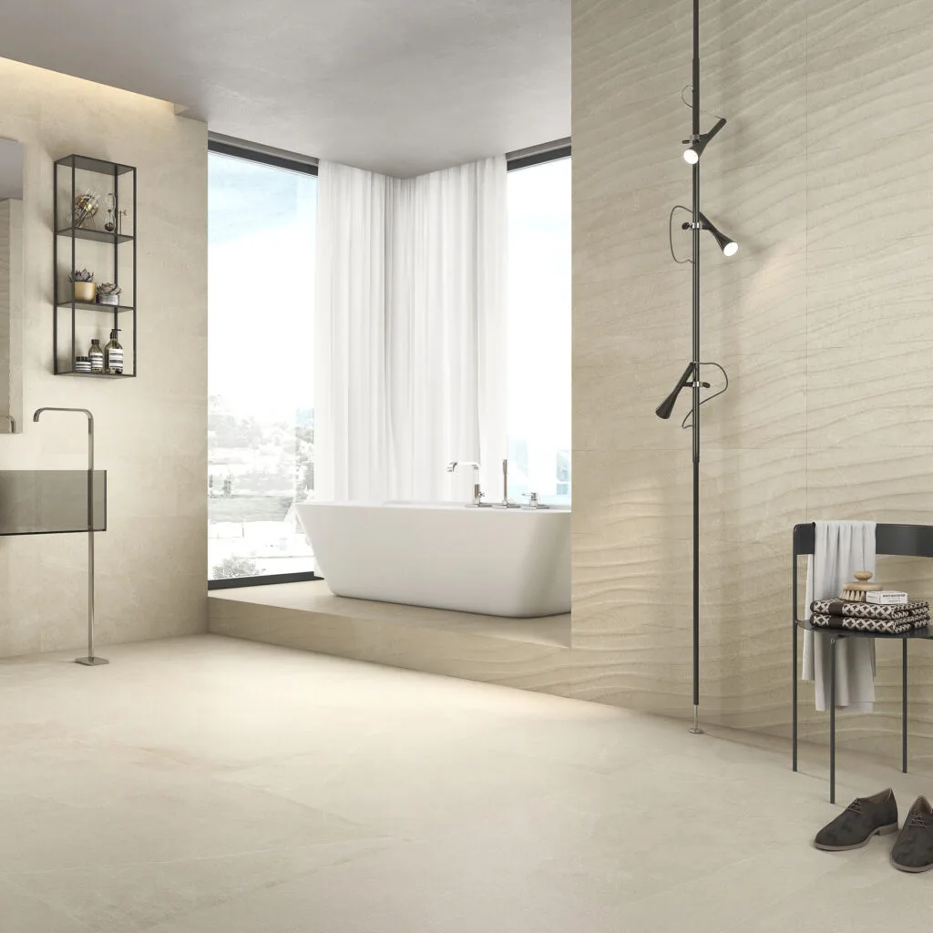 Baño con revestimiento Mixit beige y bañera exenta junto al ventanal