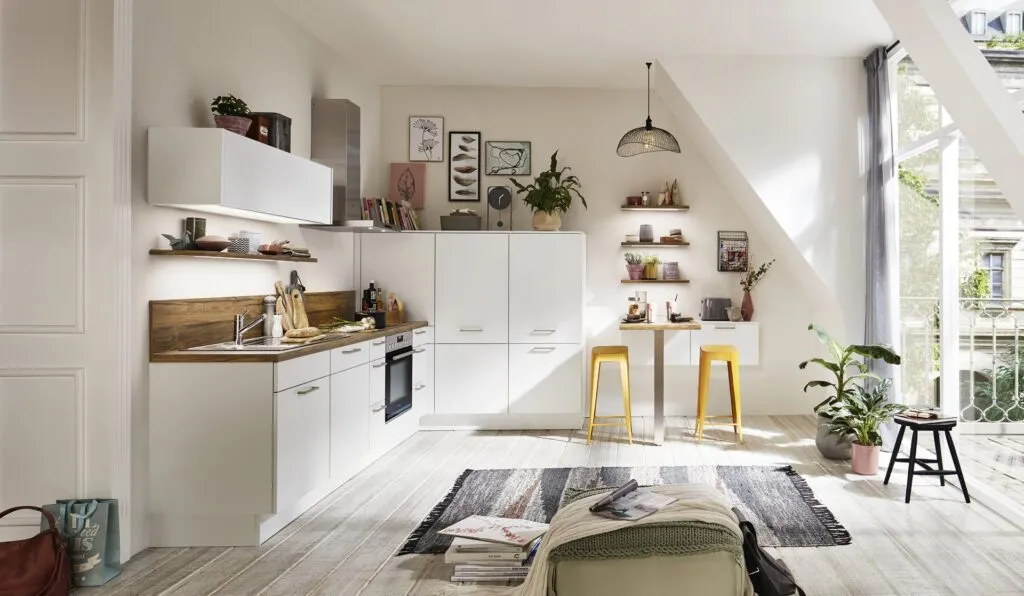 Cocina blanca compacta con estantes abiertos y barra