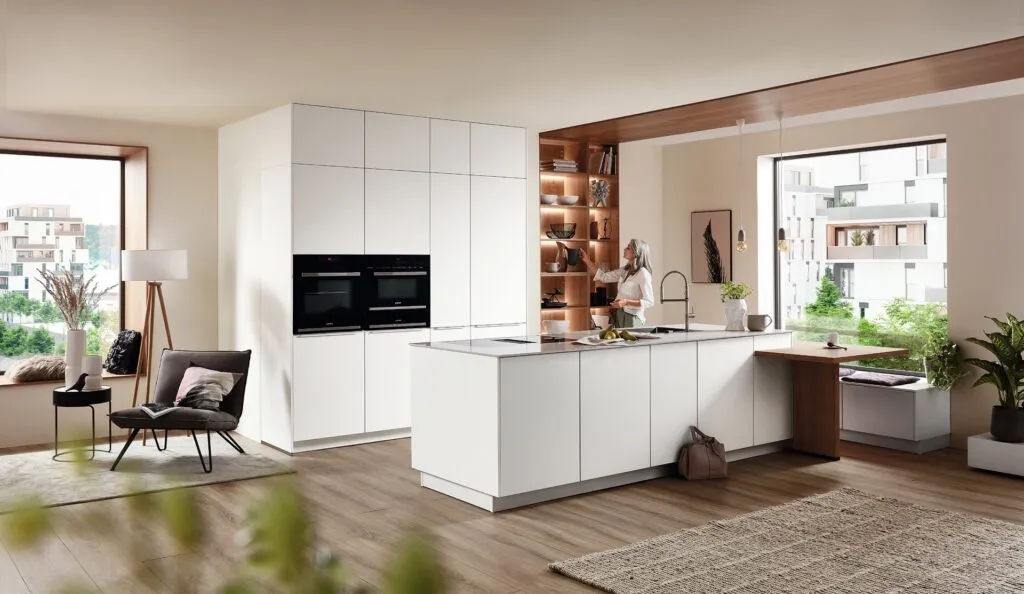Cocina blanca con isla y nicho de madera iluminado