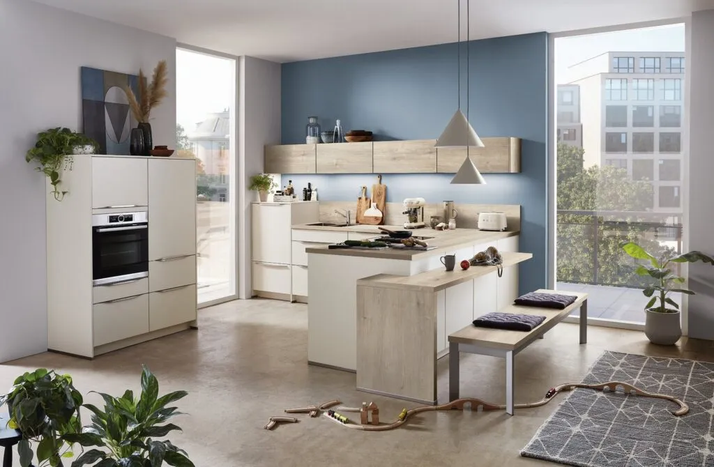 Cocina blanca con pared azul y barra de madera clara