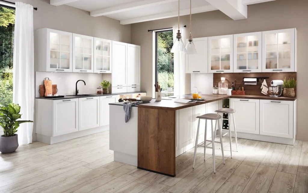 Cocina blanca con vitrinas y península con frente de madera