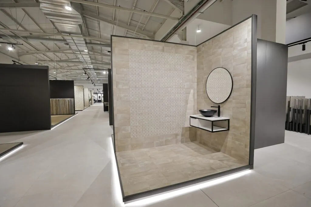 Baño expuesto con lavabo negro de sobre encimera y espejo redondo