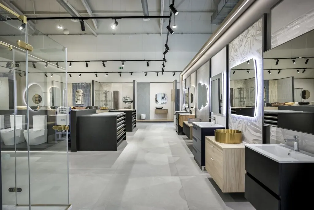 Zona de baños con mamparas y muebles de lavabo en el showroom